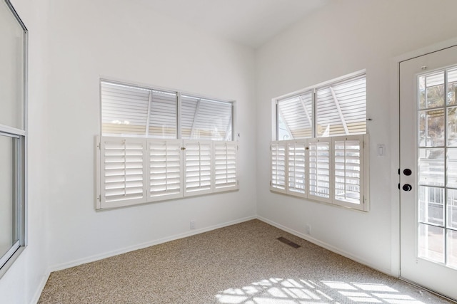 carpeted empty room with visible vents and baseboards