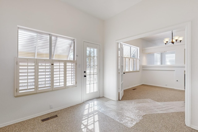 doorway to outside featuring carpet, visible vents, a notable chandelier, and baseboards