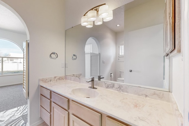 bathroom with vanity, toilet, and baseboards