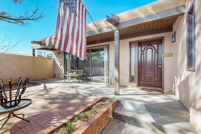 entrance to property featuring stucco siding