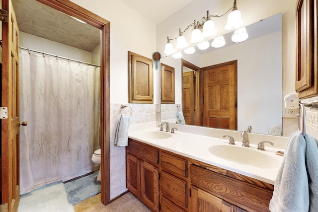 full bath featuring a sink, tile walls, toilet, and double vanity