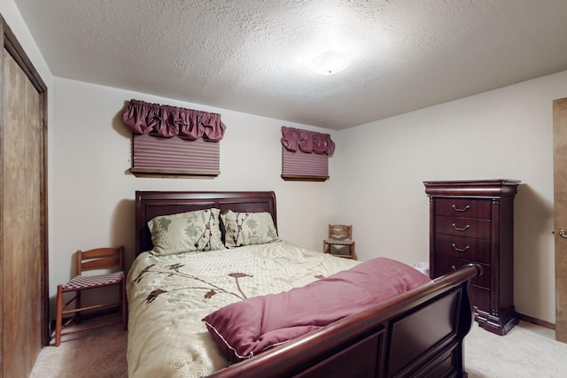 bedroom featuring light carpet, a closet, and a textured ceiling