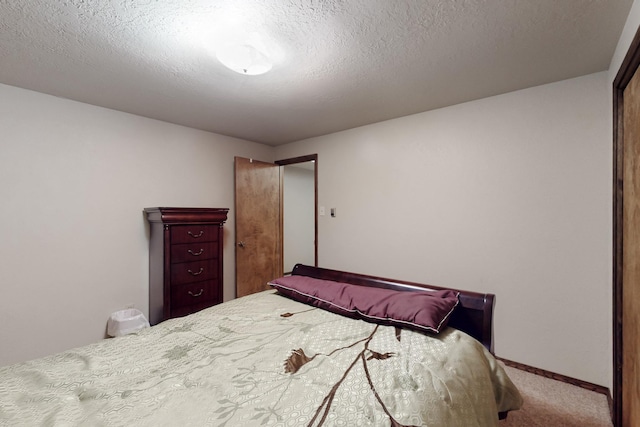 bedroom with carpet floors, a textured ceiling, and baseboards