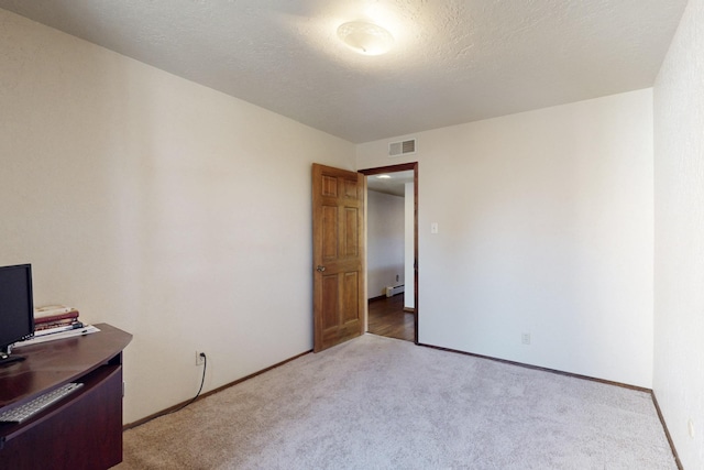 interior space with carpet, visible vents, baseboard heating, a textured ceiling, and baseboards