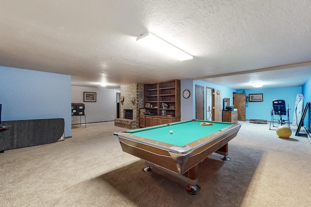 game room featuring carpet floors, a brick fireplace, pool table, and a textured ceiling