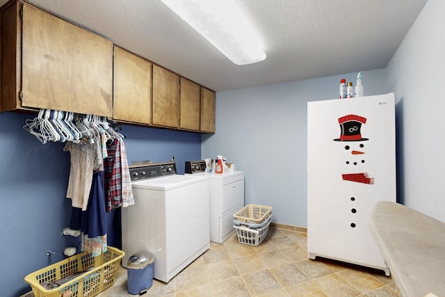 laundry room featuring cabinet space, independent washer and dryer, and a textured ceiling