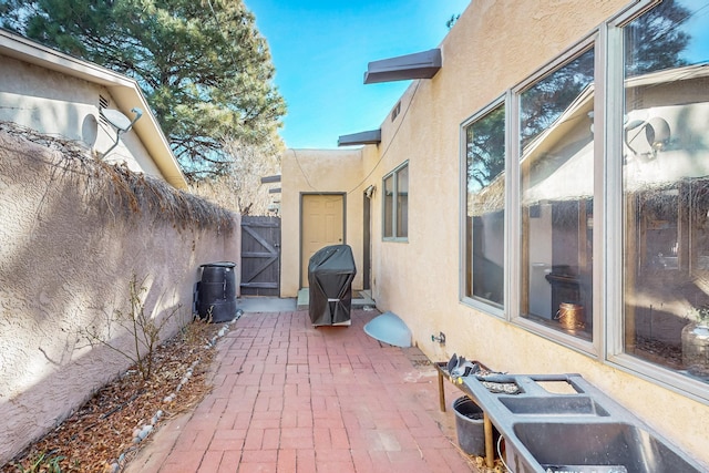 view of patio with a gate, a grill, and fence