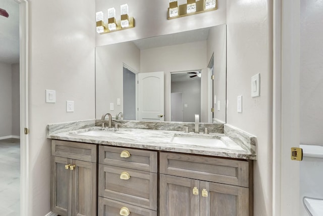 bathroom featuring double vanity, a ceiling fan, and a sink