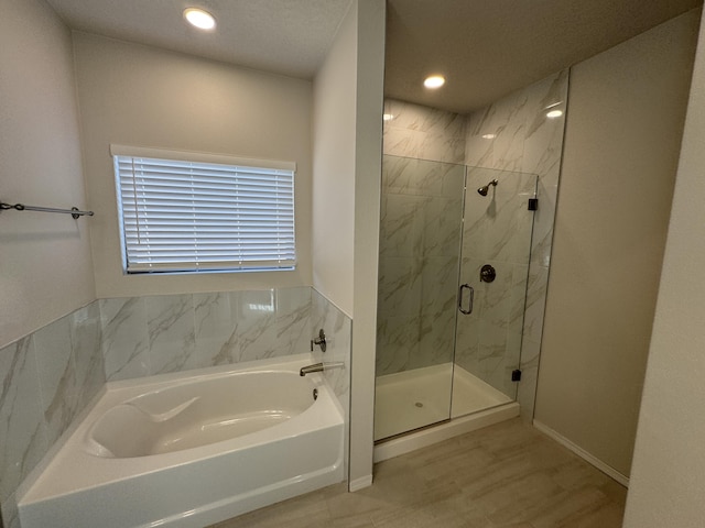 bathroom with a bath, a marble finish shower, recessed lighting, and baseboards