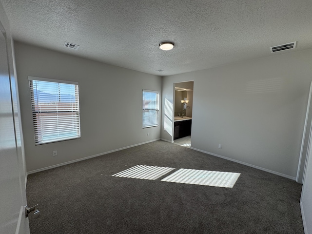 unfurnished bedroom featuring visible vents, carpet flooring, and multiple windows