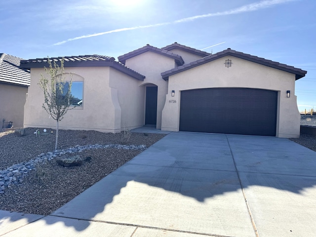 ranch-style house featuring a tiled roof, stucco siding, concrete driveway, and an attached garage