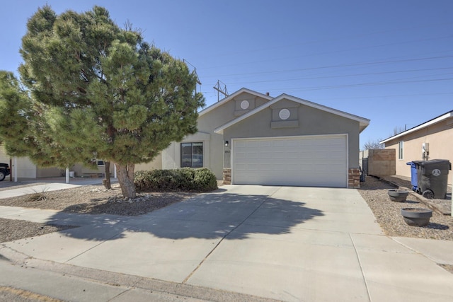 ranch-style home featuring concrete driveway, a garage, stone siding, and stucco siding