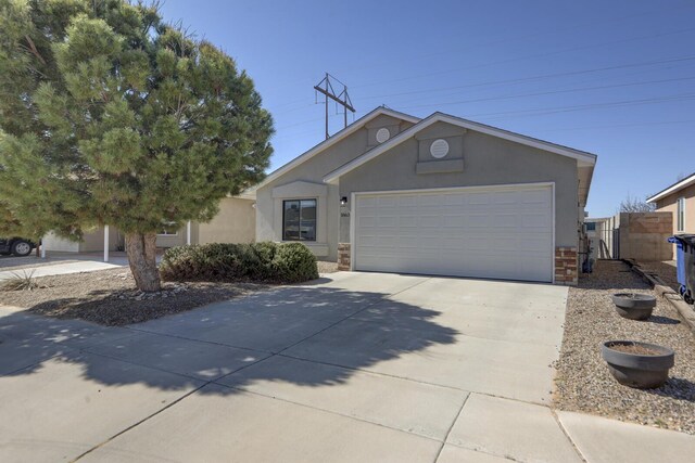 ranch-style home featuring stone siding, stucco siding, concrete driveway, and a garage