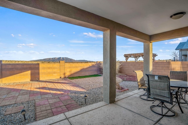 view of patio / terrace with a mountain view, a fenced backyard, and outdoor dining space