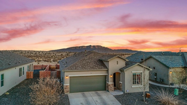 view of front of property featuring stucco siding, a mountain view, concrete driveway, and a garage