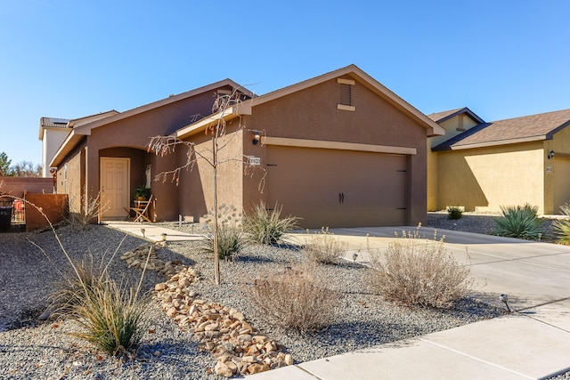 view of front of home featuring a garage, driveway, and stucco siding