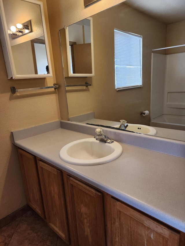 full bath with shower / tub combination, vanity, and tile patterned flooring