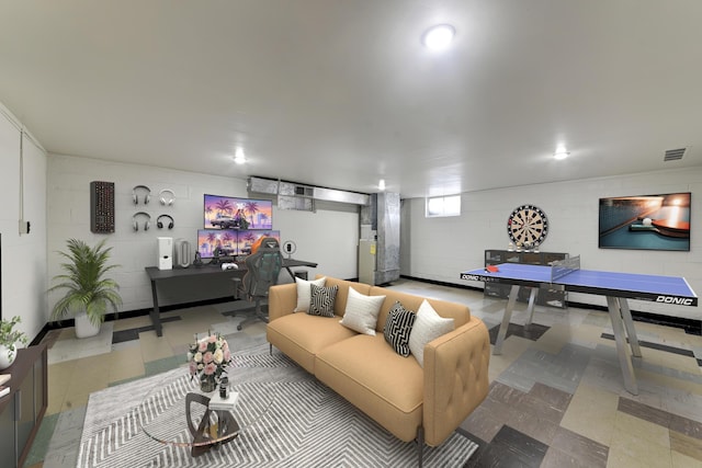 living room featuring concrete block wall and visible vents