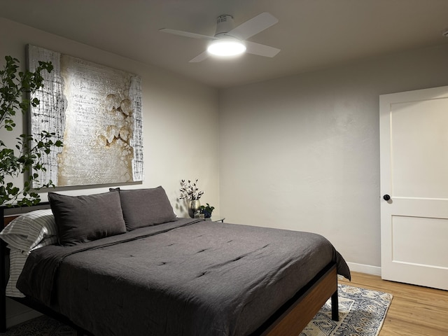 bedroom featuring light wood-style floors, ceiling fan, and baseboards