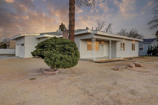 view of front of house with a porch and stucco siding