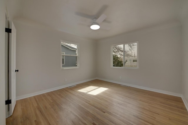 empty room with light wood finished floors, visible vents, baseboards, and a ceiling fan