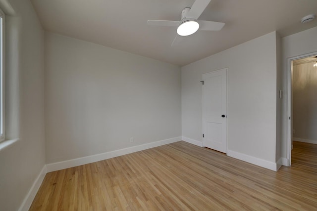 unfurnished room featuring light wood-type flooring, baseboards, and a ceiling fan