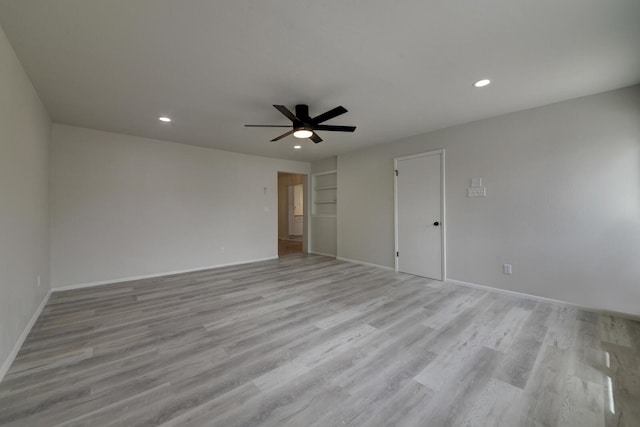 unfurnished room with baseboards, a ceiling fan, light wood-type flooring, built in shelves, and recessed lighting