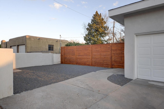 view of patio / terrace with a garage and fence