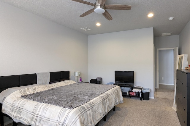 bedroom with baseboards, visible vents, light carpet, and a textured ceiling