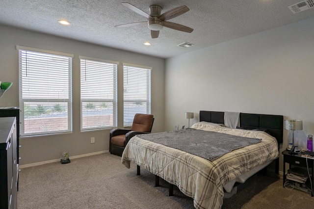 bedroom with carpet floors, visible vents, a textured ceiling, and baseboards