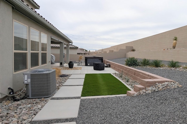 view of yard featuring central air condition unit, a fenced backyard, and a patio