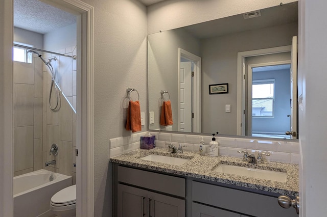 full bath featuring visible vents, a sink, a textured ceiling, and toilet