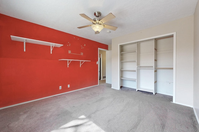 unfurnished bedroom with baseboards, a ceiling fan, a textured ceiling, carpet floors, and a closet