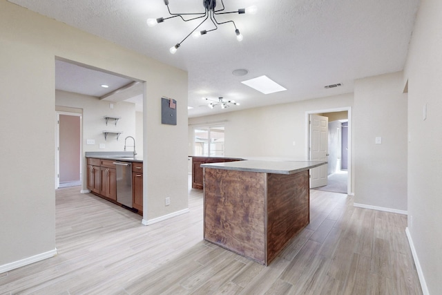 kitchen with light wood-type flooring, baseboards, and stainless steel dishwasher