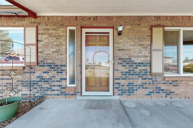 doorway to property with brick siding