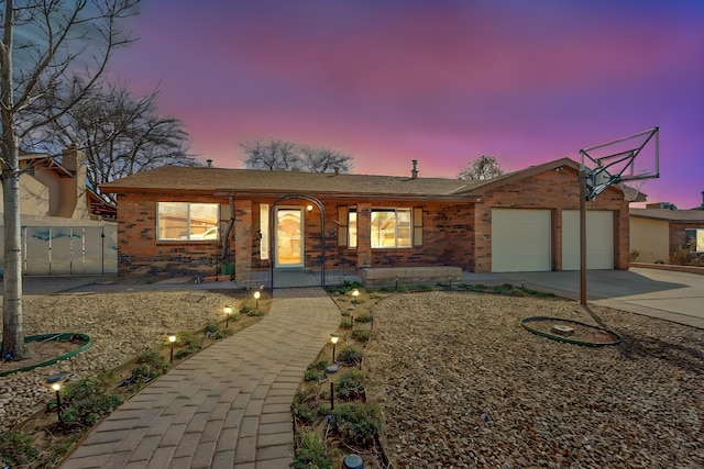 view of front of home featuring covered porch, brick siding, driveway, and an attached garage