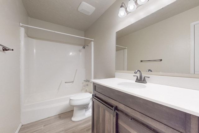 bathroom featuring toilet, washtub / shower combination, wood finished floors, and vanity