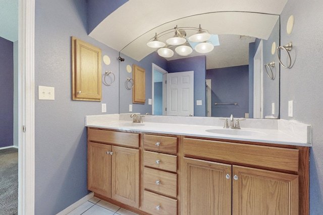 full bath with double vanity, baseboards, a sink, and tile patterned floors