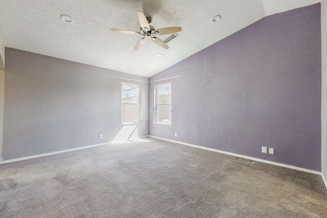 carpeted spare room featuring vaulted ceiling, a textured wall, a textured ceiling, and baseboards