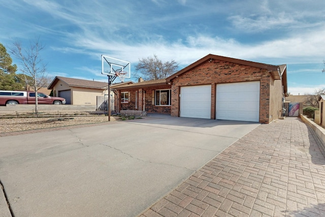 ranch-style home with a garage, concrete driveway, and brick siding