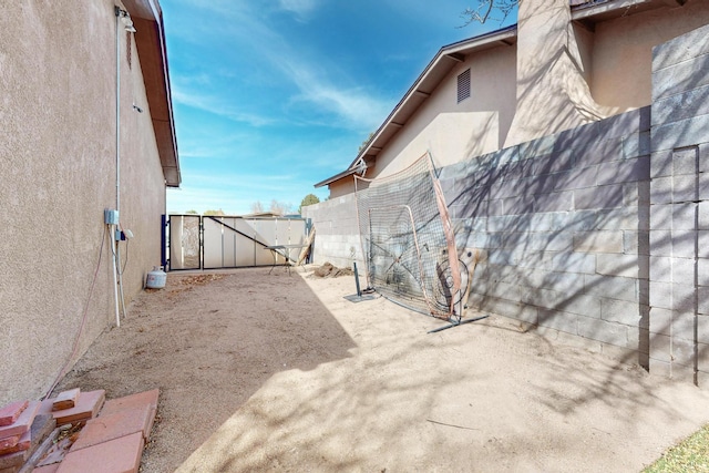 exterior space with a patio area, fence, and a gate