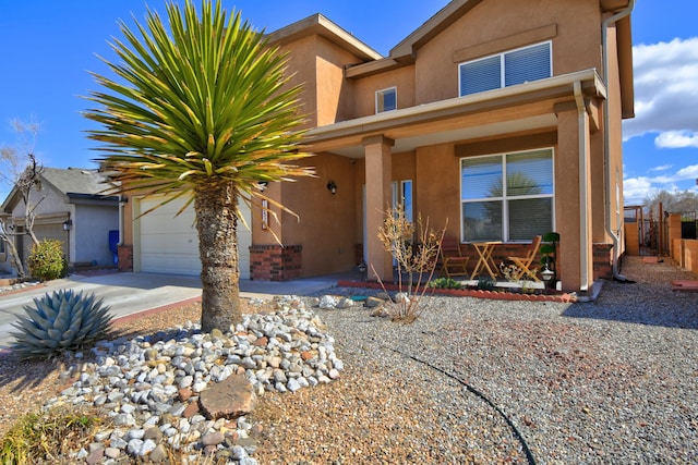 view of front facade with concrete driveway, an attached garage, and stucco siding