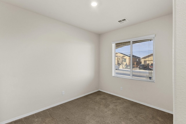 carpeted spare room with baseboards and visible vents