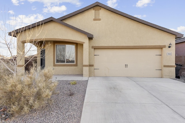 view of front of house with driveway, a garage, and stucco siding