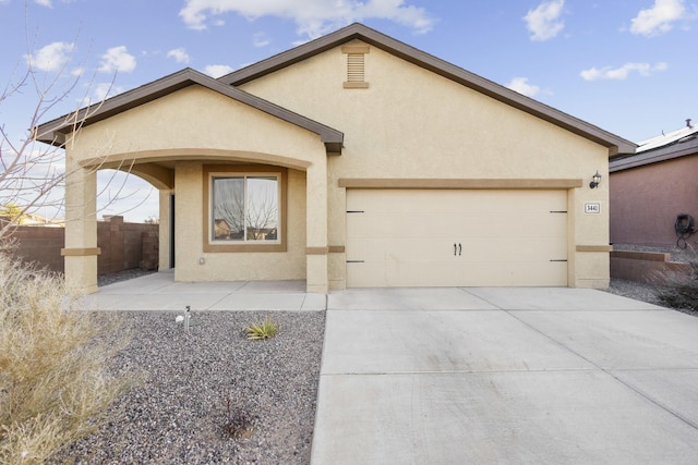 view of front of home featuring a garage, driveway, fence, and stucco siding