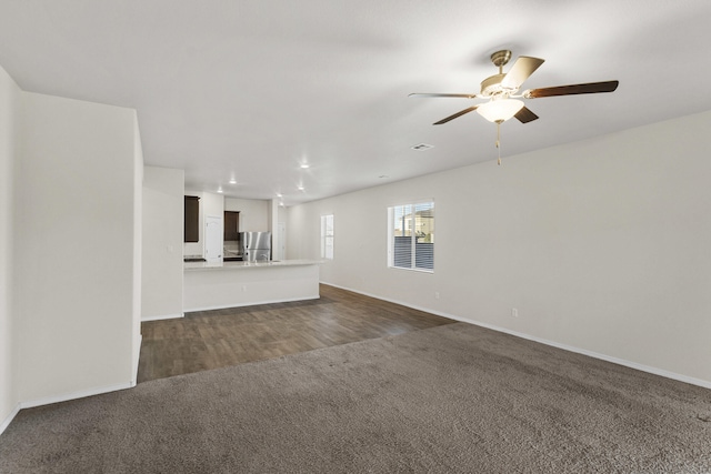 unfurnished living room featuring a ceiling fan, recessed lighting, dark carpet, and baseboards