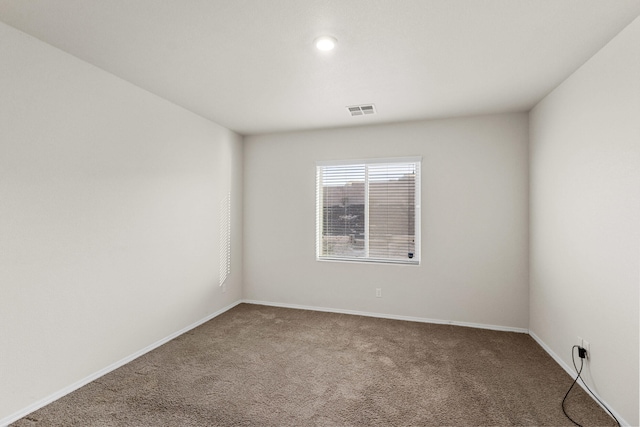 carpeted empty room with visible vents and baseboards