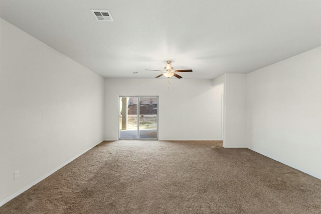 empty room with carpet floors, visible vents, and ceiling fan