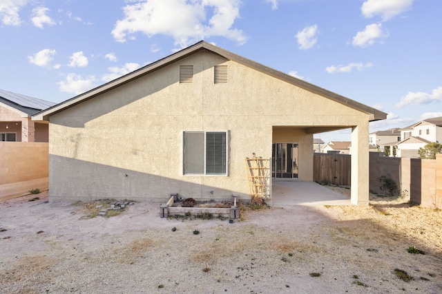 rear view of house with a patio area, a fenced backyard, and stucco siding