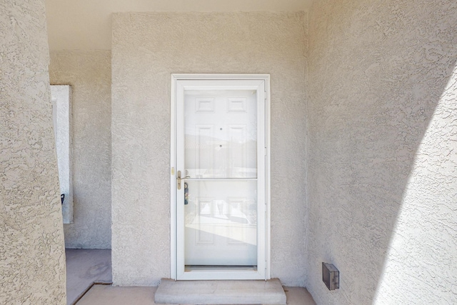 view of exterior entry with stucco siding